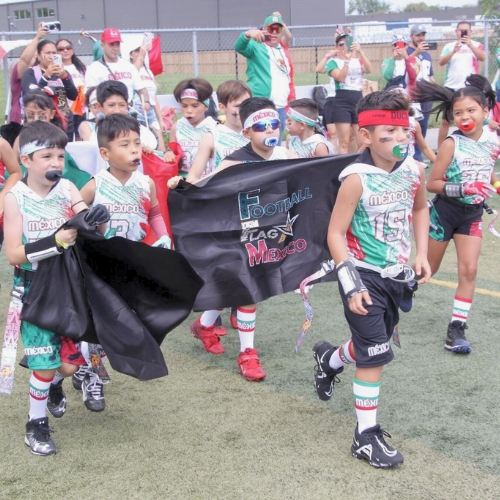 Niños entrando a campo de fútbol para jugar tocho